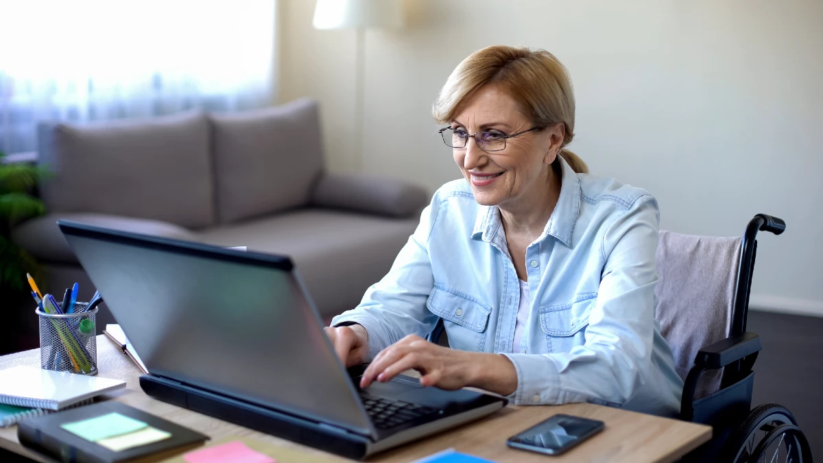 Image of woman sitting in wheelchair at computer screen